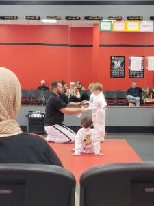 5 yr old getting his white belt tied on him